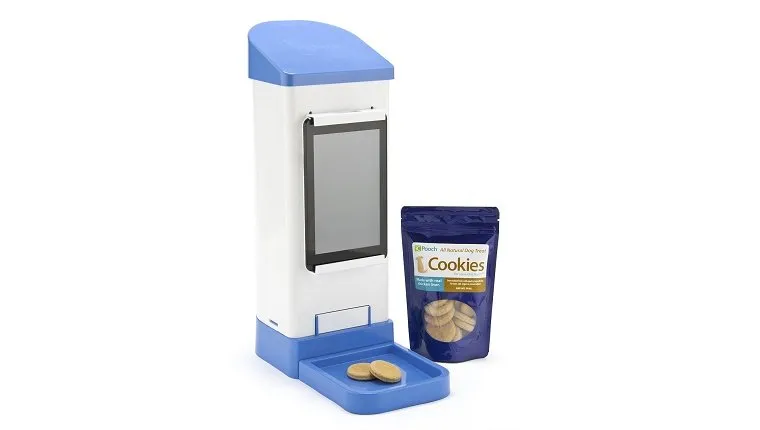 A tall treat dispenser has a package of dog cookies next to it.